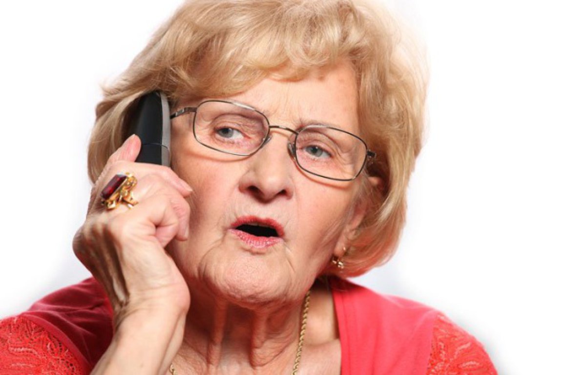 Пожилая женщина звонит по телефону
