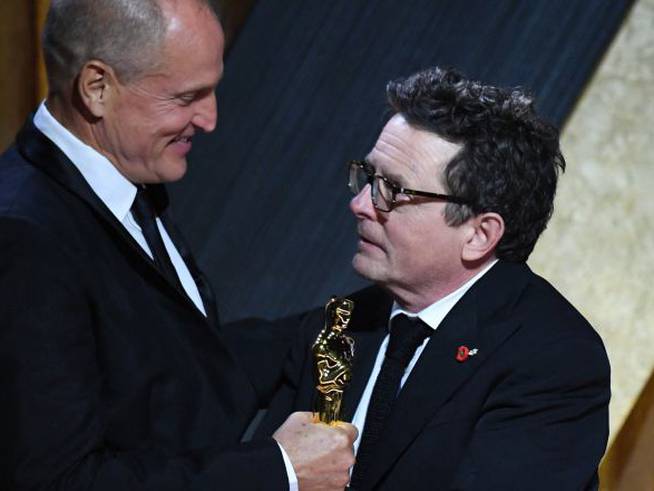 Woody Harrelson entregándole el premio a su amigo Michael J. Fox.