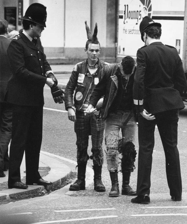 La policía de Londres detienen a dos Punks durante la manifestación anárquica “Stop the City” en 1984.