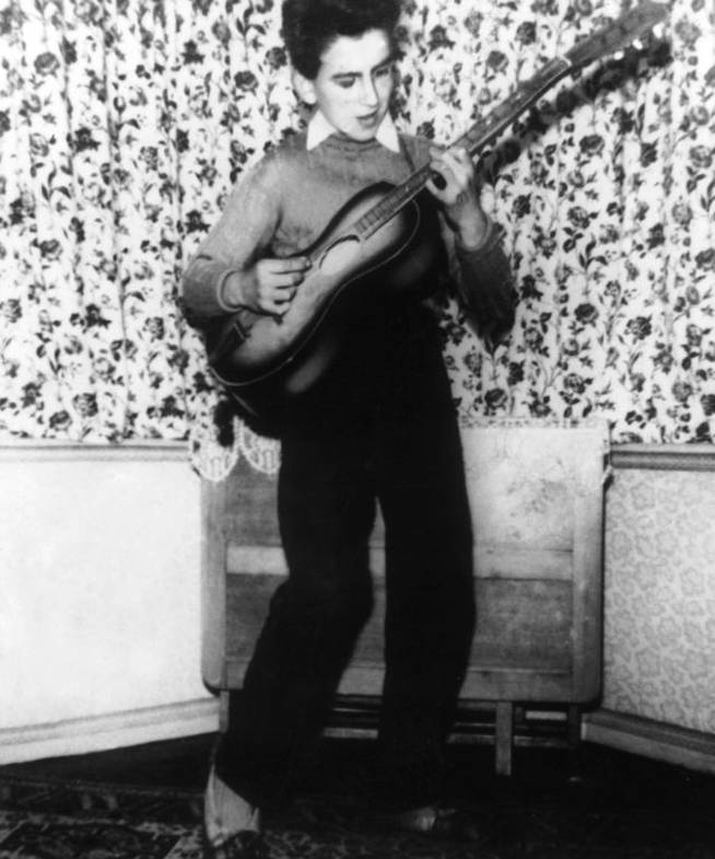 George Harrison tocando la guitarra en su casa de Liverpool cuando tenía 12 años.