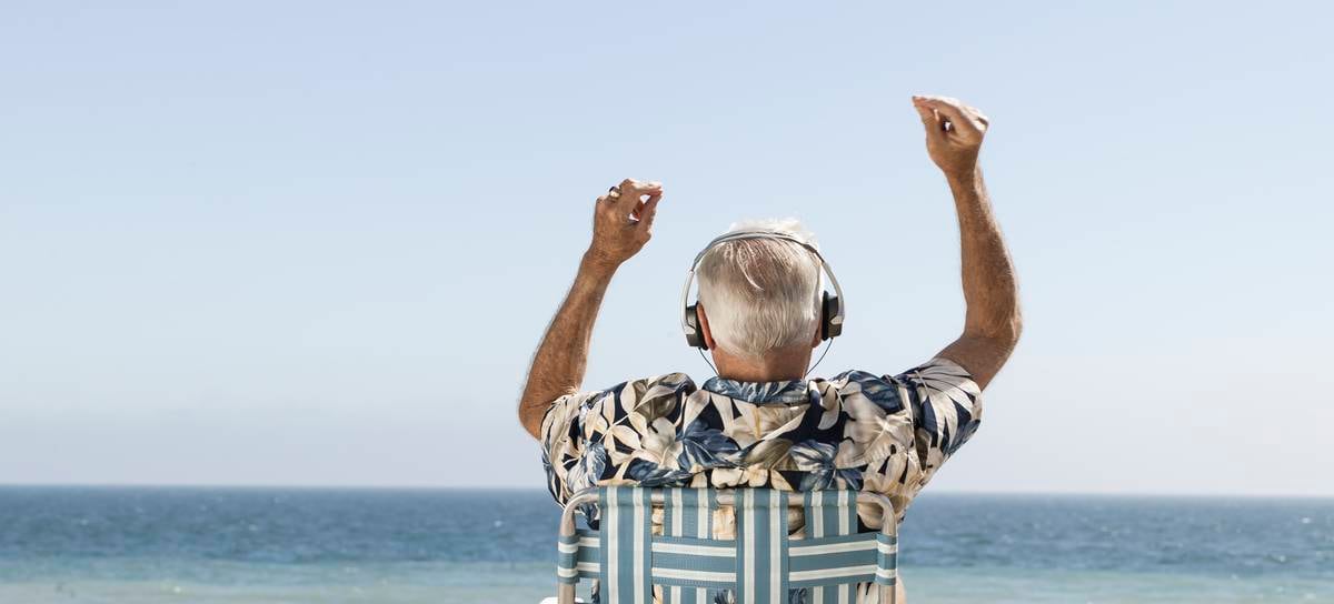 Un hombre escuchando música en la hamaca y frente al mar.