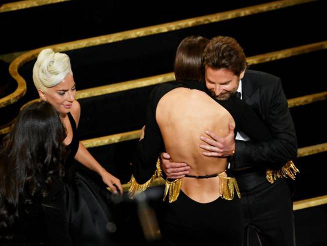 Abrazos entre Bradley Cooper, Lady Gaga e Irina Shayk tras ganar un Oscar.