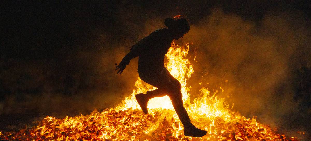 Un joven salta una hoguera en la Noche de San Juan.