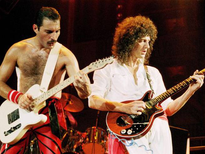 Freddie Mercury y Brian May tocando la guiatarra.