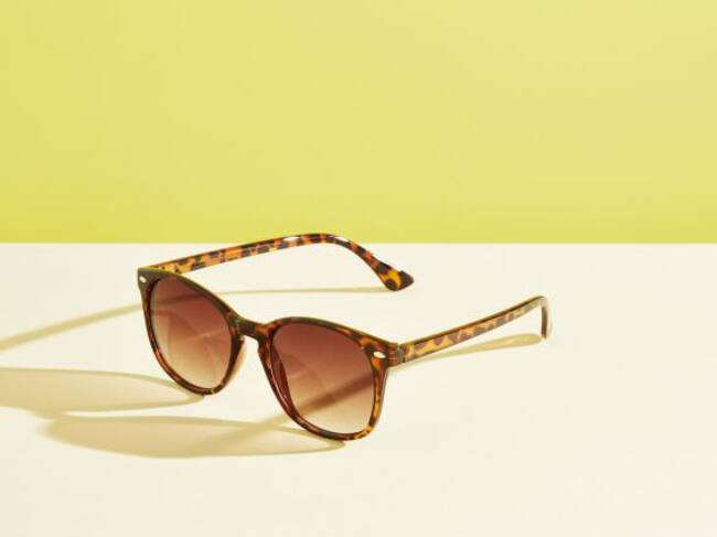 Unas gafas de sol sobre un fondo amarillo.
