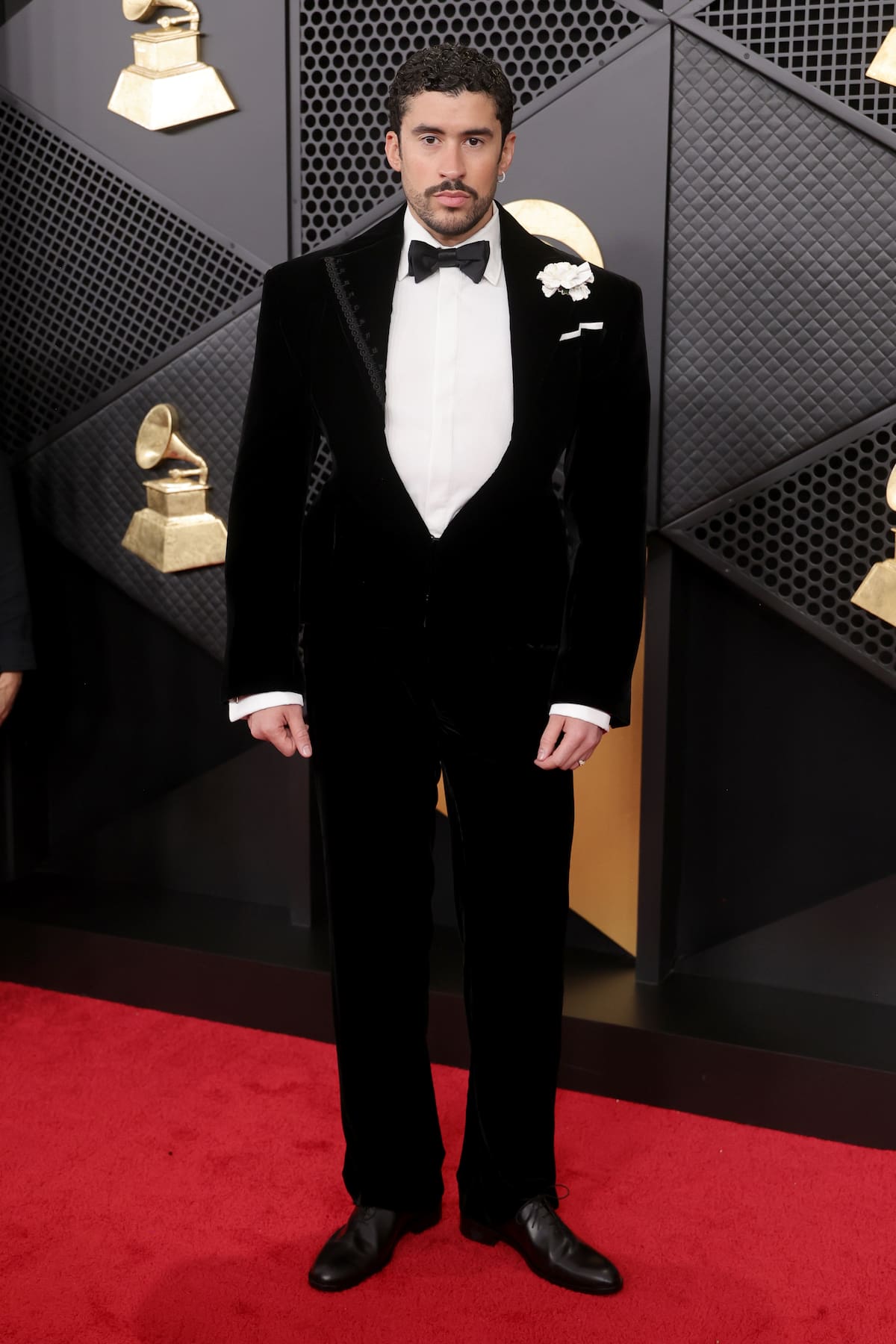 El hombre del momento que tiene a todo el mundo en vilo por su próxima actuación en la Super Bowl apareció en los Grammy como gran favorito y vestido impecablemente con un esmoquin de Schiaparelli de terciopelo negro y un clavel blanco en la solapa. Esta vez sin gorra y con pajarita.