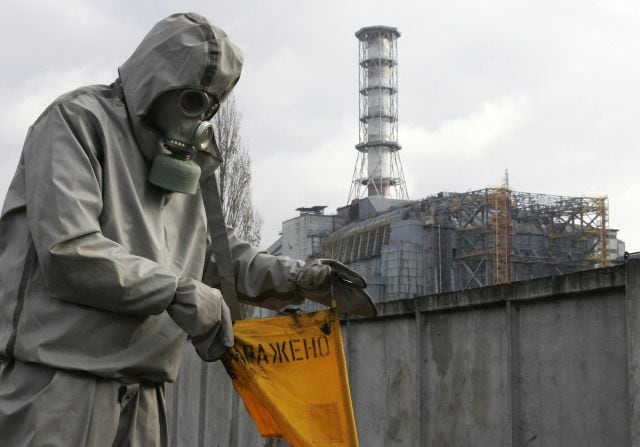 Un hombre con un traje antiradiactivo recorre las inmediaciones de la estación nuclear de Chernóbil, en Ucrania, en 2006.