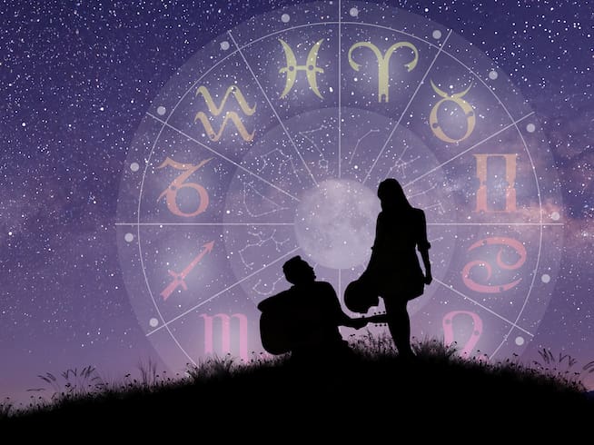 Una pareja canta y baila sobre la rueda del zodíaco, mientras contemplan las estrellas.