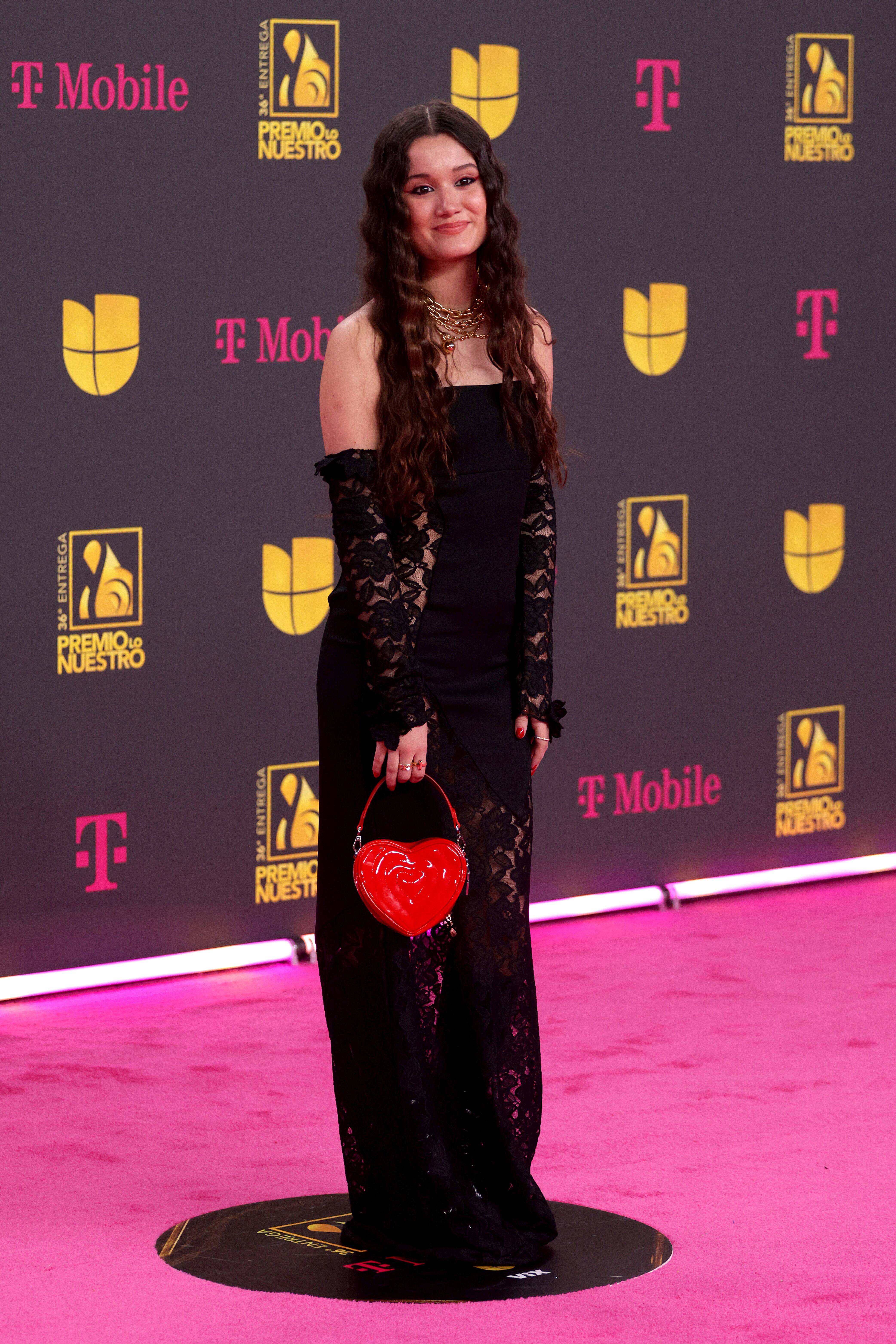 La venezolana no se salió del negro más habitual con un vestido palabra de honor con encaje en la falda a juego con el de los guantes. La nota de color la puso con su bolso corazón.