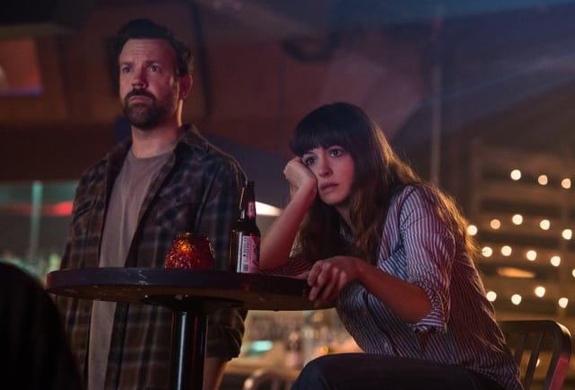 Jason Sudeikis y Anne Hathaway viendo la vida pasar en el bar en un fotograma de Colossal / Neon