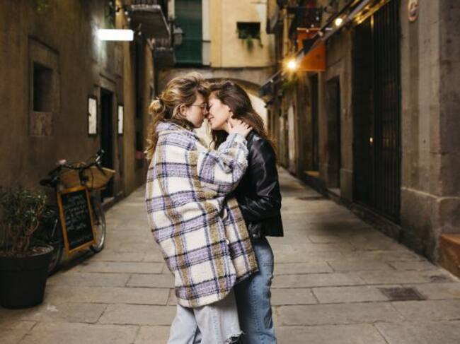 Una pareja en actitud cariño paseando por las calles de un pueblo.