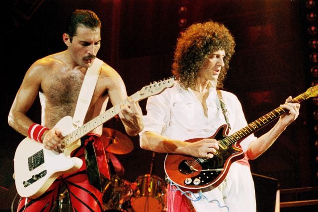 Freddie Mercury y Brian May tocando la guiatarra.