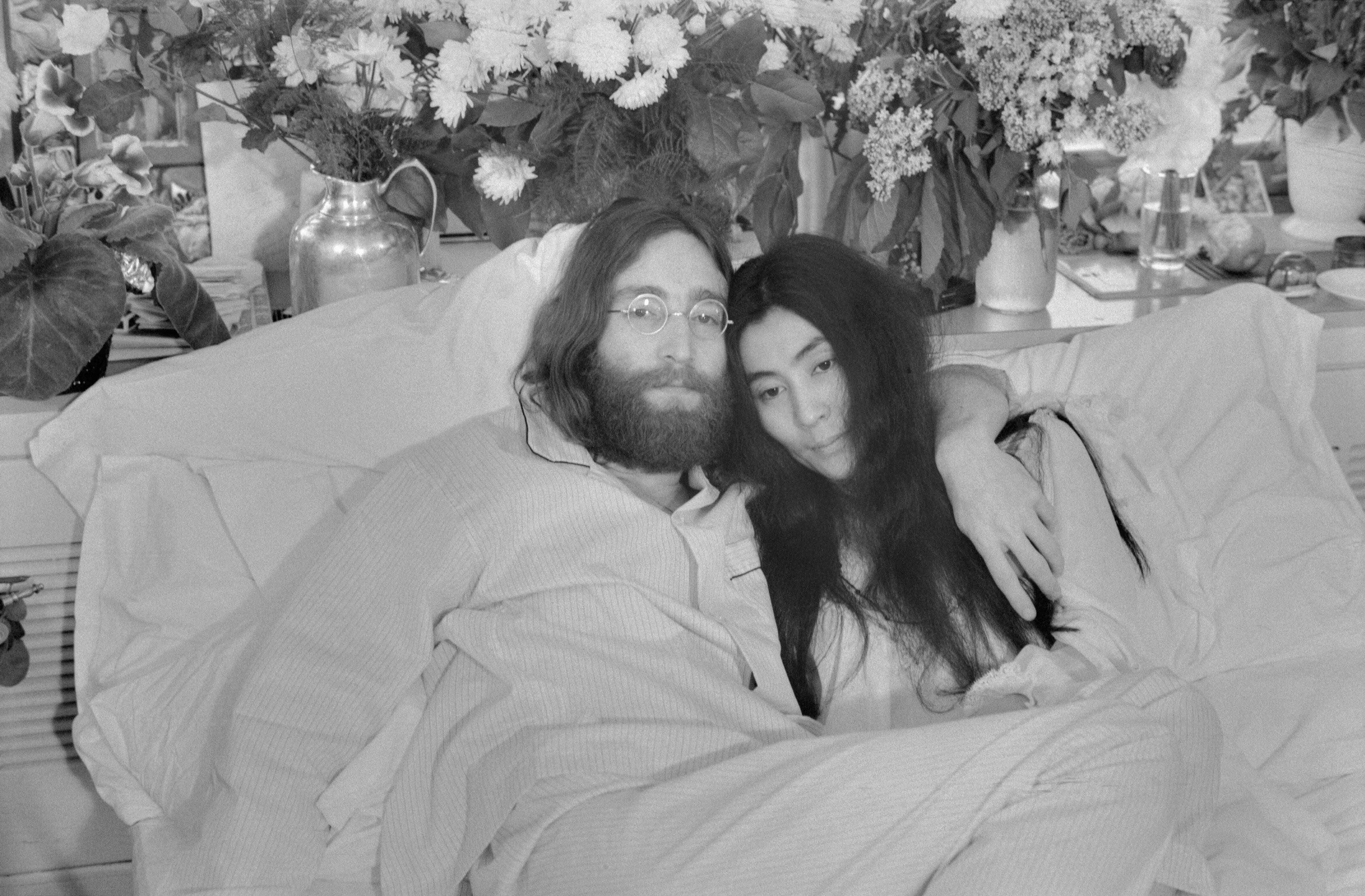 Yoko y John... El Beatle John Lennon y Yoko Ono —con quien llevaba casado tres meses cuando se tomó esta fotografía en Montreal, en junio de 1969— posan en la cama. Por aquel entonces, su primer álbum en solitario incluía canciones que hablaban de su amor por Yoko. Ambos ofrecieron ruedas de prensa desde la cama en varias ciudades bajo el lema «haz el amor y no la guerra». Lennon murió tiroteado el 8 de diciembre de 1980. En un comunicado emitido el 9 de diciembre, Yoko Ono declaró: «No habrá funeral para John. Más adelante esta semana fijaremos la hora de una vigilia silenciosa para rezar por su alma. Les invitamos a participar desde dondequiera que se encuentren en ese momento».
