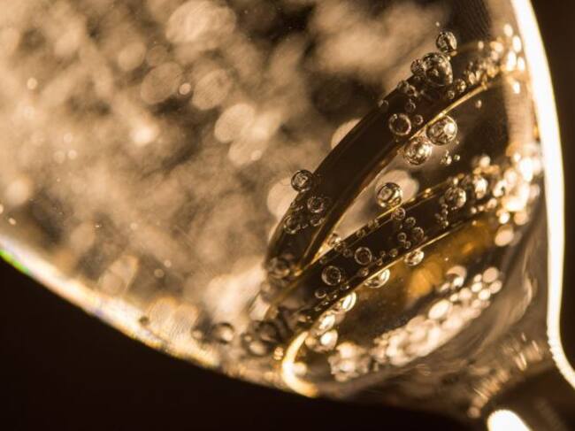 Dos anillos sumerigdos en una copa de champagne.