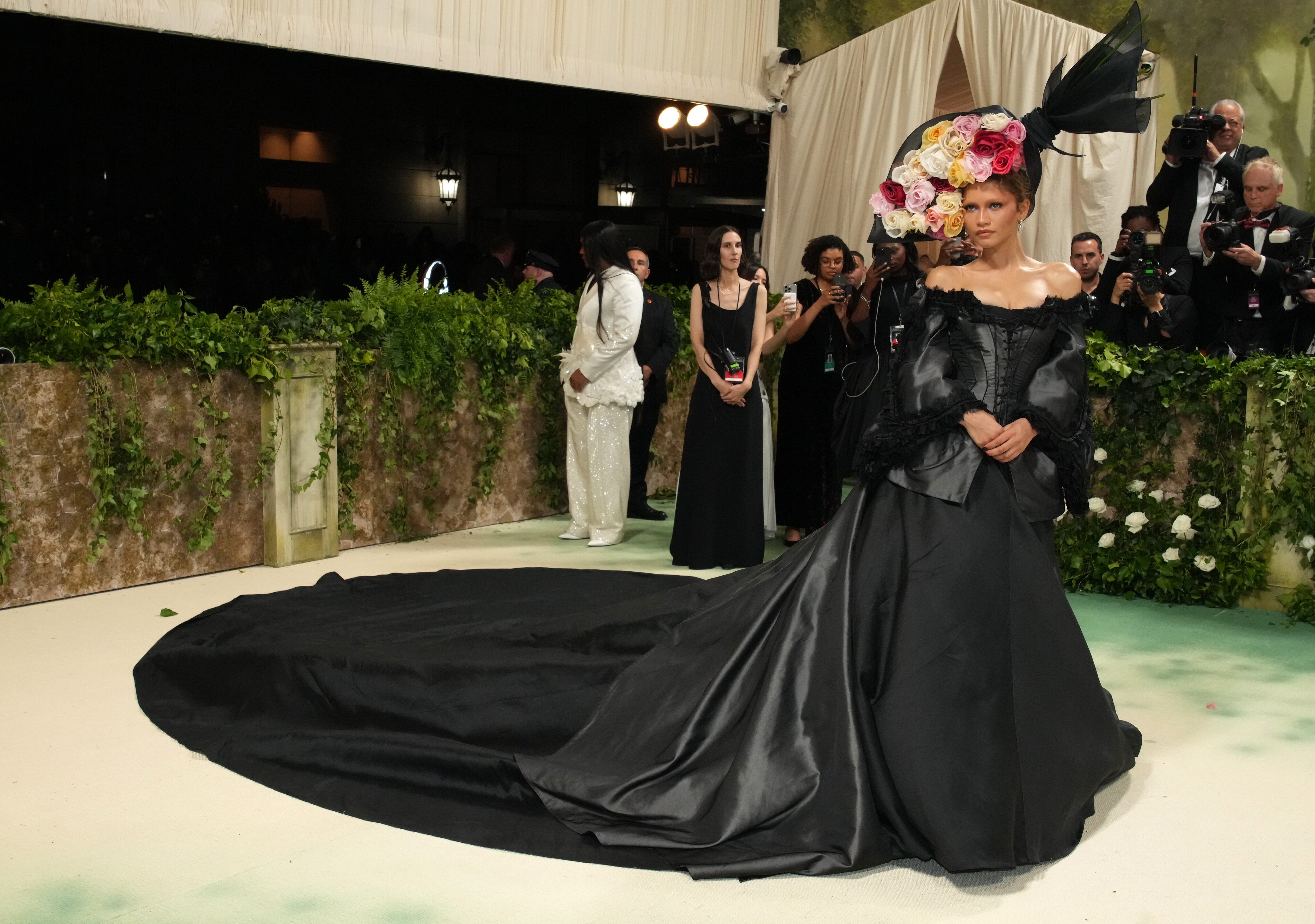 Segundo vestido de la noche, también de Galliano, en esta ocasión para Givency. Una imagen muy victoriana con ese vestido negro con gran cola y corsé palabra de honor. Todas las miradas se dirigían al tocado de Philip Treacy en forma de gran ramo de rosas.