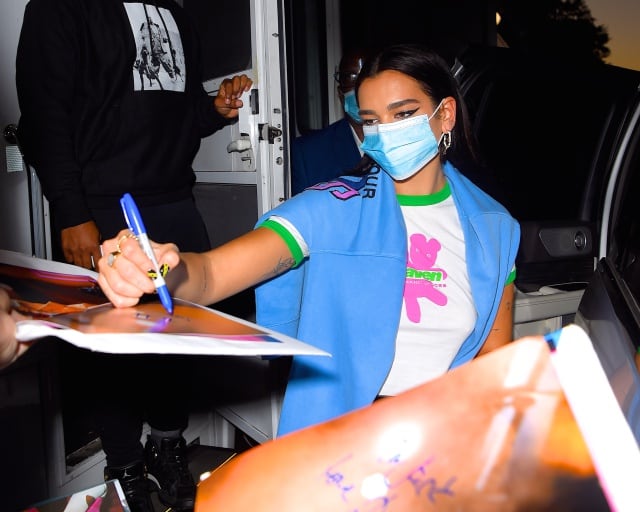 Dua Lipa firmando autógrafos en Nueva York durante el rodaje del videoclip de su tema con Cyrus