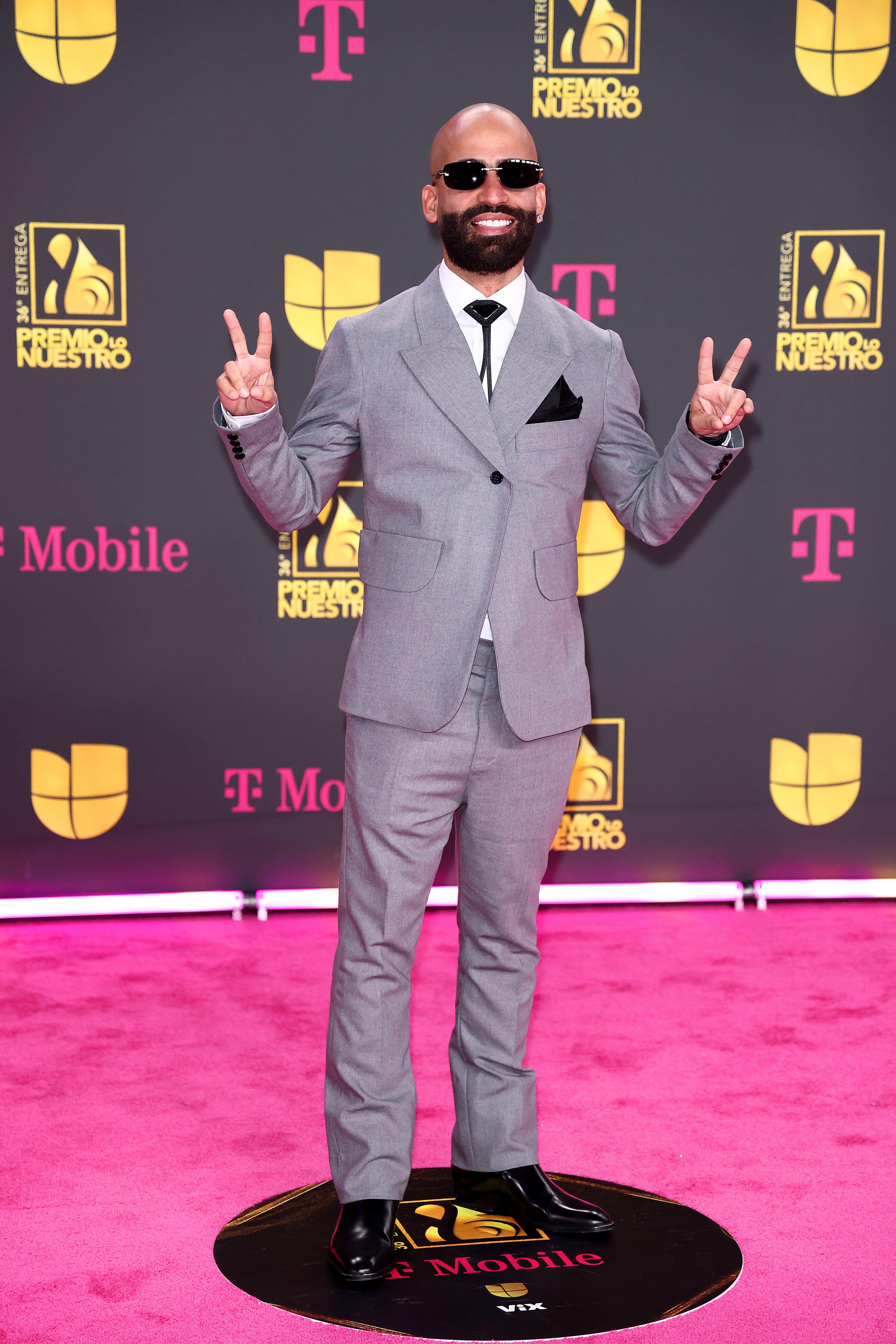 Paz y buen rollo de Arcángel en la alfombra con la sobriedad de un traje gris iluminado solo por su sonrisa.