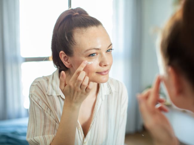 Chica echándose crema en la cara