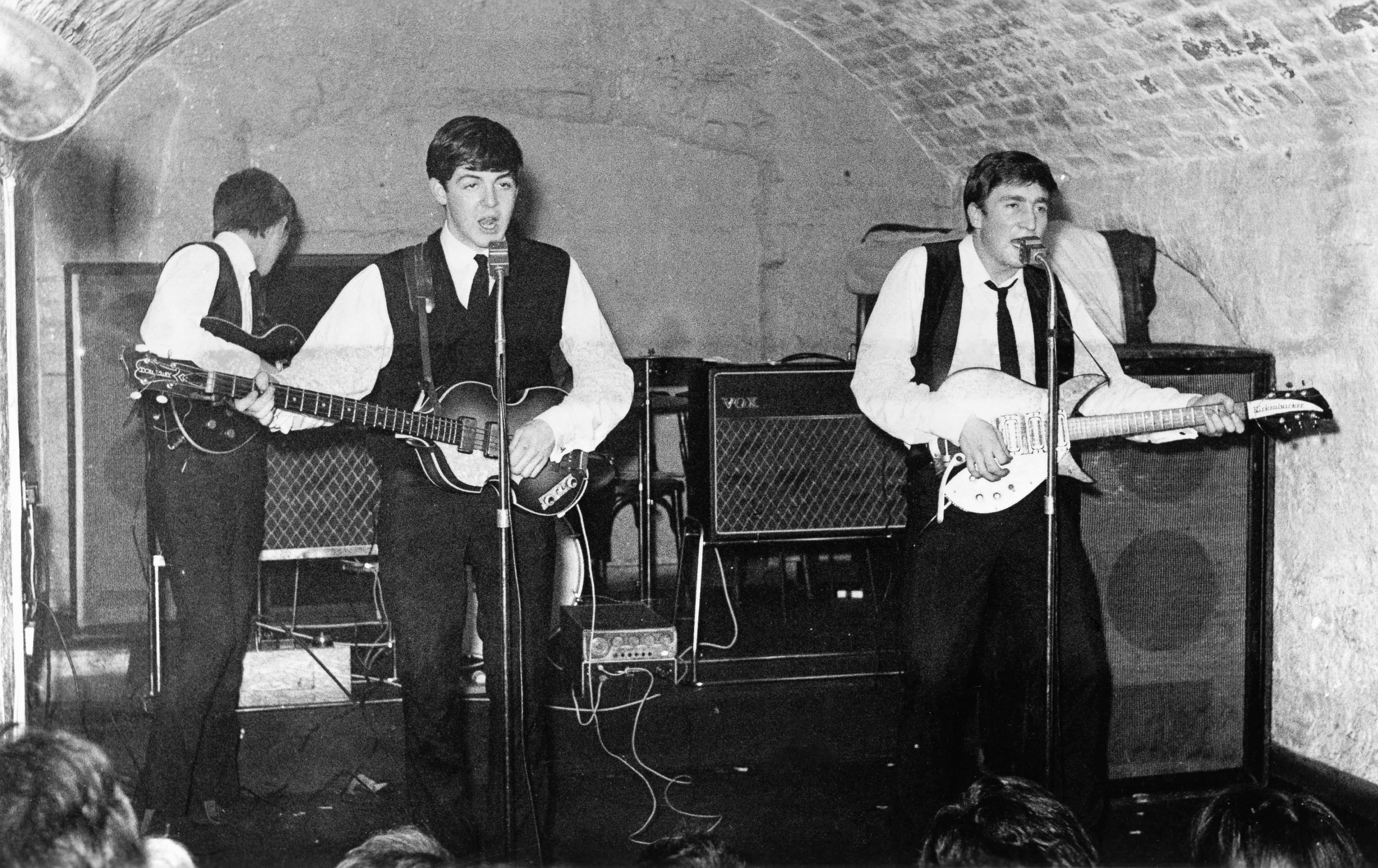 LIVERPOOL - 22 DE AGOSTO: La banda de rock and roll "The Beatles" actúa en el escenario del Cavern Club el 22 de agosto de 1962. (De izquierda a derecha) George Harrison, Paul McCartney, John Lennon. (Foto de Michael Ochs Archives/Getty Images)