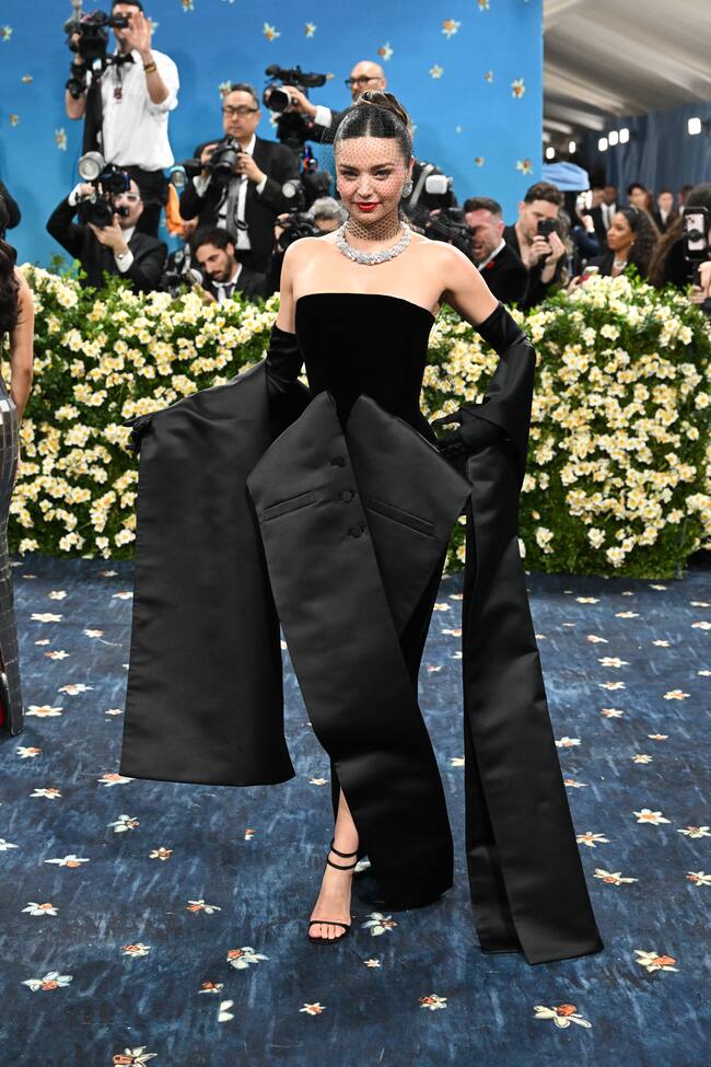 Miranda Kerr lucía un impresionante vestido de terciopelo negro palabra de honor con un adorno inspirado en un chaleco masculino. No pasaban desapercibidas la maxiestola satinada y el velo.