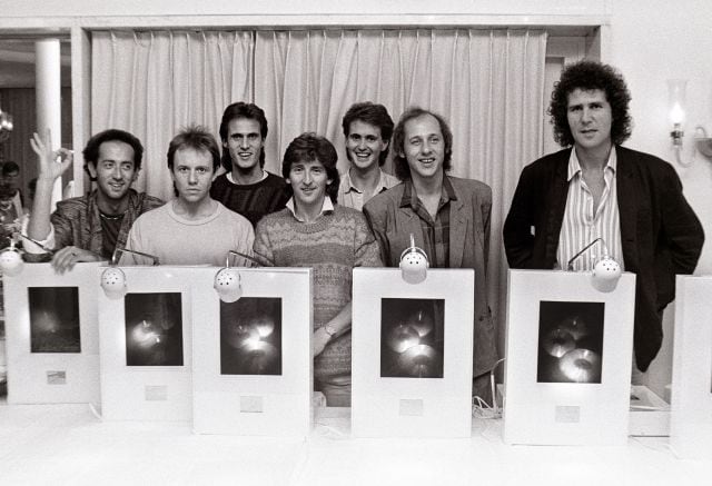 Dire Straits posan con un premio por las ventas de discos en 1985.