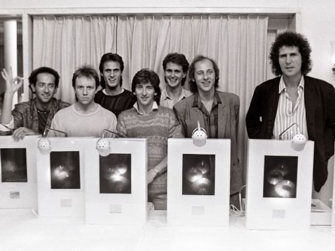 Dire Straits posan con un premio por las ventas de discos en 1985.