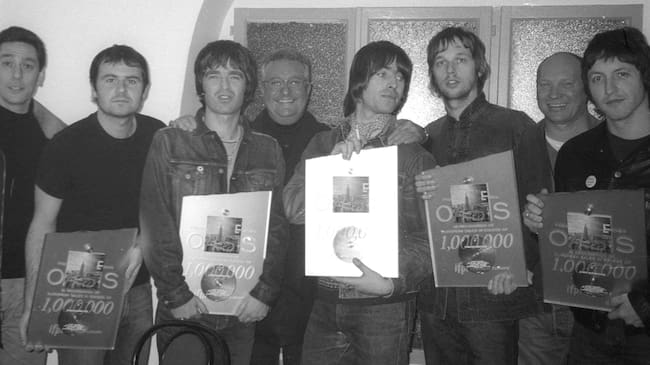 Noel Gallagher (nacido en 1967), cantautor británico, Liam Gallagher (nacido en 1972), cantante y músico británico, y los integrantes de su banda de rock Oasis, reciben un disco de diamante en su camerino del Bataclan. París (distrito 11), 21 de marzo de 2000. (Foto de Christian Rose/Roger Viollet vía Getty Images)