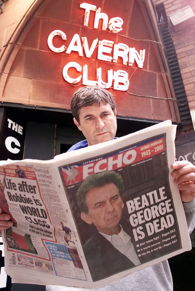 Un ciudadano de Liverpool lee en el periódico la muerte del Beatle George Harrison a las puertas del famoso local The Cavern Club.