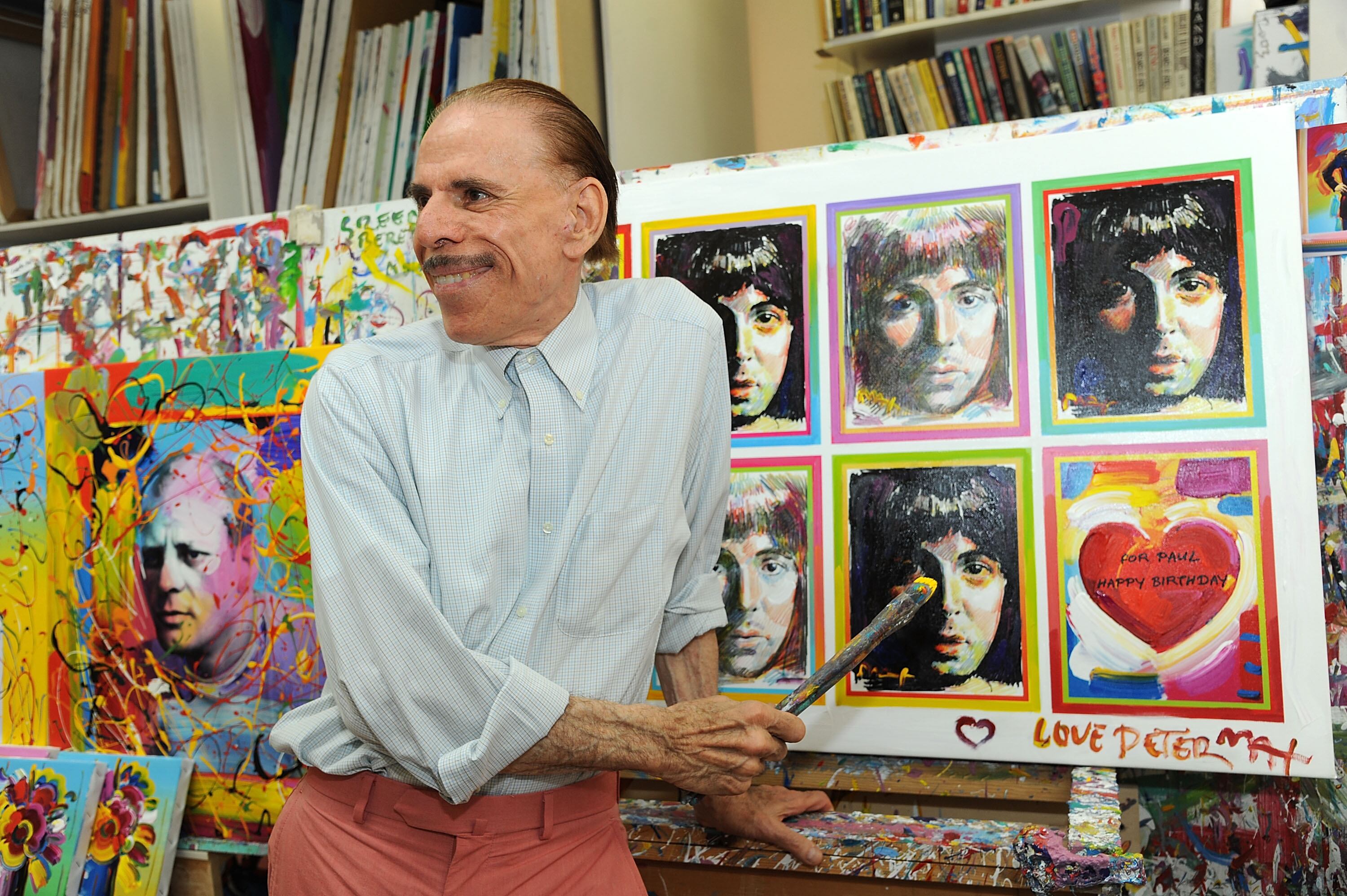 Peter Max junto a su serie de retratos a Paul McCartney, en su estudio de Nueva York, en 2012.