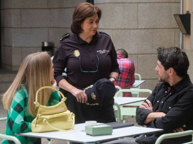Claudia Mirales charla con algunos de los agentes de policía de la comisaría en una terraza.