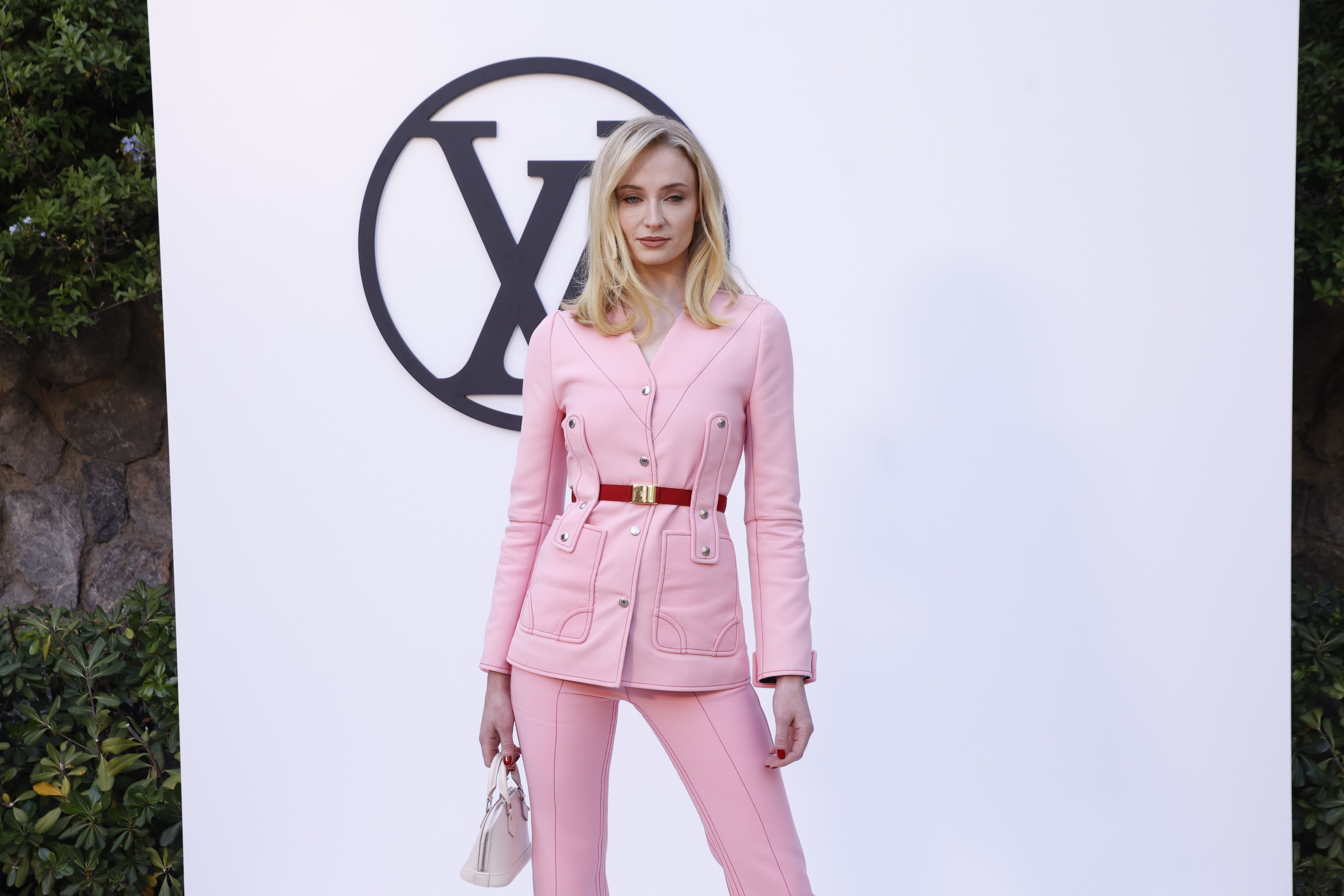 Melena rubia y corto bob para Sophie Turner que ha apostado por un look muy Barbie con este traje de pantalón y chaqueta.