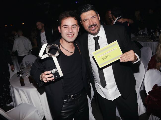 Tony Aguilar y DePol posan sonrientes. El artista catalán con su premio a Mejor Artista Del 40 al 1 y el presentador muestra el tarjetón con el nombre de DePol.