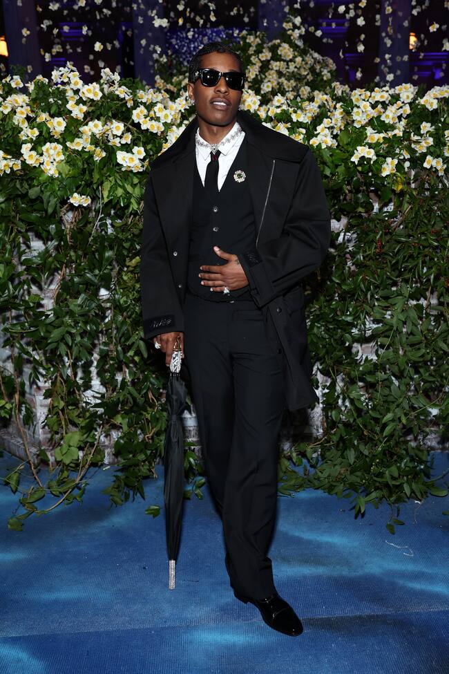 Anna Wintour sugirió a A$AP Rocky que recurriera a un diseñador negro y él, uno de los anfitriones de la noche, optó por diseñarse su propio traje con su agencia creativa AWGE. Chaqueta negra y paraguas adornado con diamantes. Llego bastante antes que su chica, Rihanna.