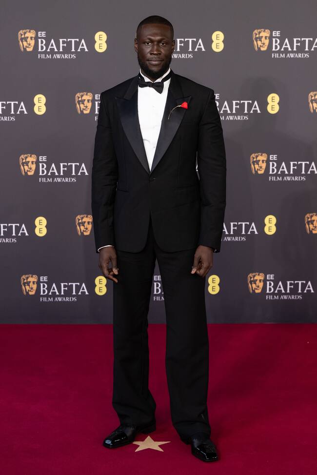 Tal vez la pajarita del cantante Stormzy necesitara un reajuste, pero no podemos quejarnos de detalle de la flor en la solapa de su traje de Gucci.