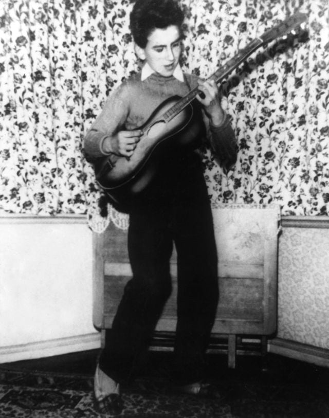 George Harrison tocando la guitarra en su casa de Liverpool cuando tenía 12 años.