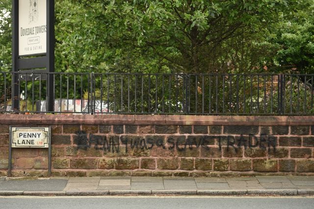 Graffitti en el que se puede leer &quot;Penny fue un traficante de esclavos&quot; pintado en la pared de Penny Lane en Liverpool.