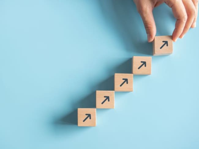 Un hombre organiza una escalaera con bloques de madera.