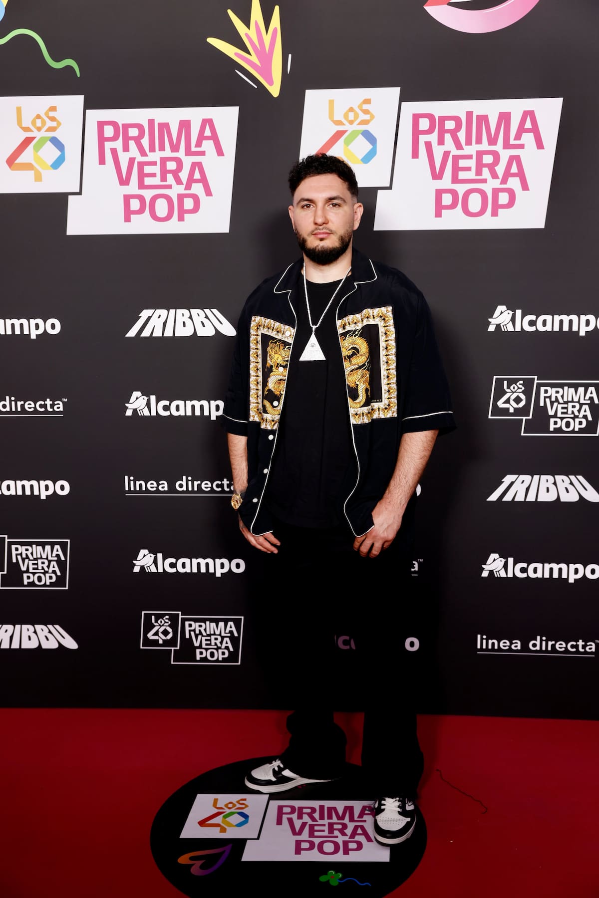 Omar Montes ha lucido muy Versace en la alfombra de LOS40 Primavera Pop 2026 con esta camisa abierta en dorado.