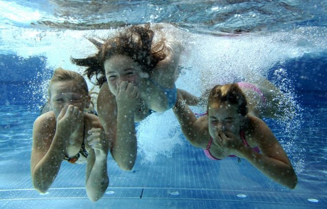 Chicas jugando en una piscina.