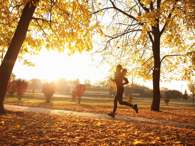 Mujer joven corriendo al aire libre en otoño. Getty.