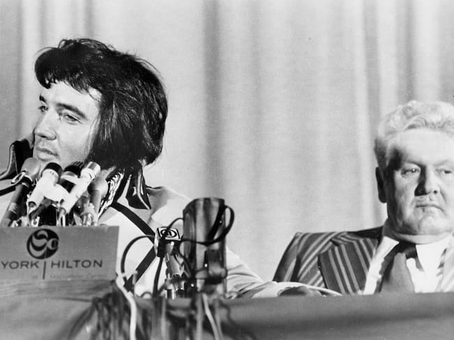 Elvis Presley en una conferencia de prensa junto a su padre Vernon
