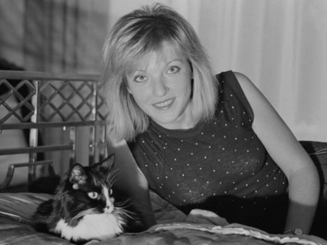 Mary Austin en un posado en blanco y negro en la cama en Reino Unido.