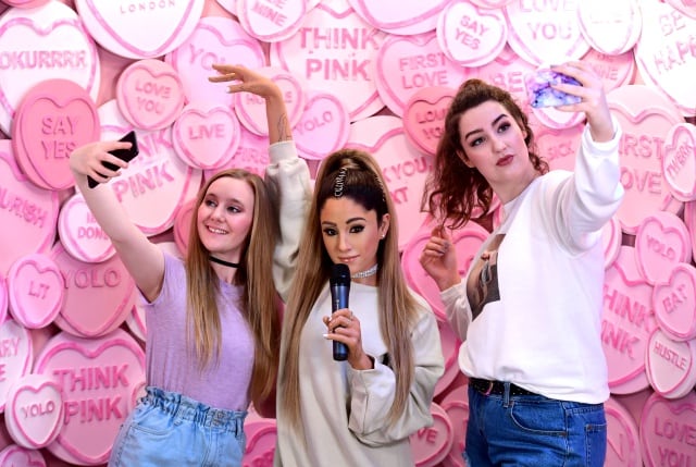 Fans posan junto a la figura de Ariana Grande en el Madame Tussauds de Londres