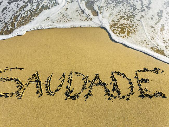 La palabra portuguesa Saudade grabada en la arena.