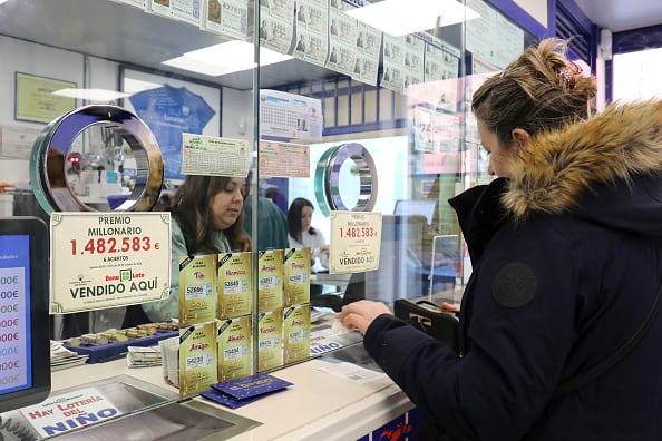 Una mujer compra su décimo para la Lotería de Navidad