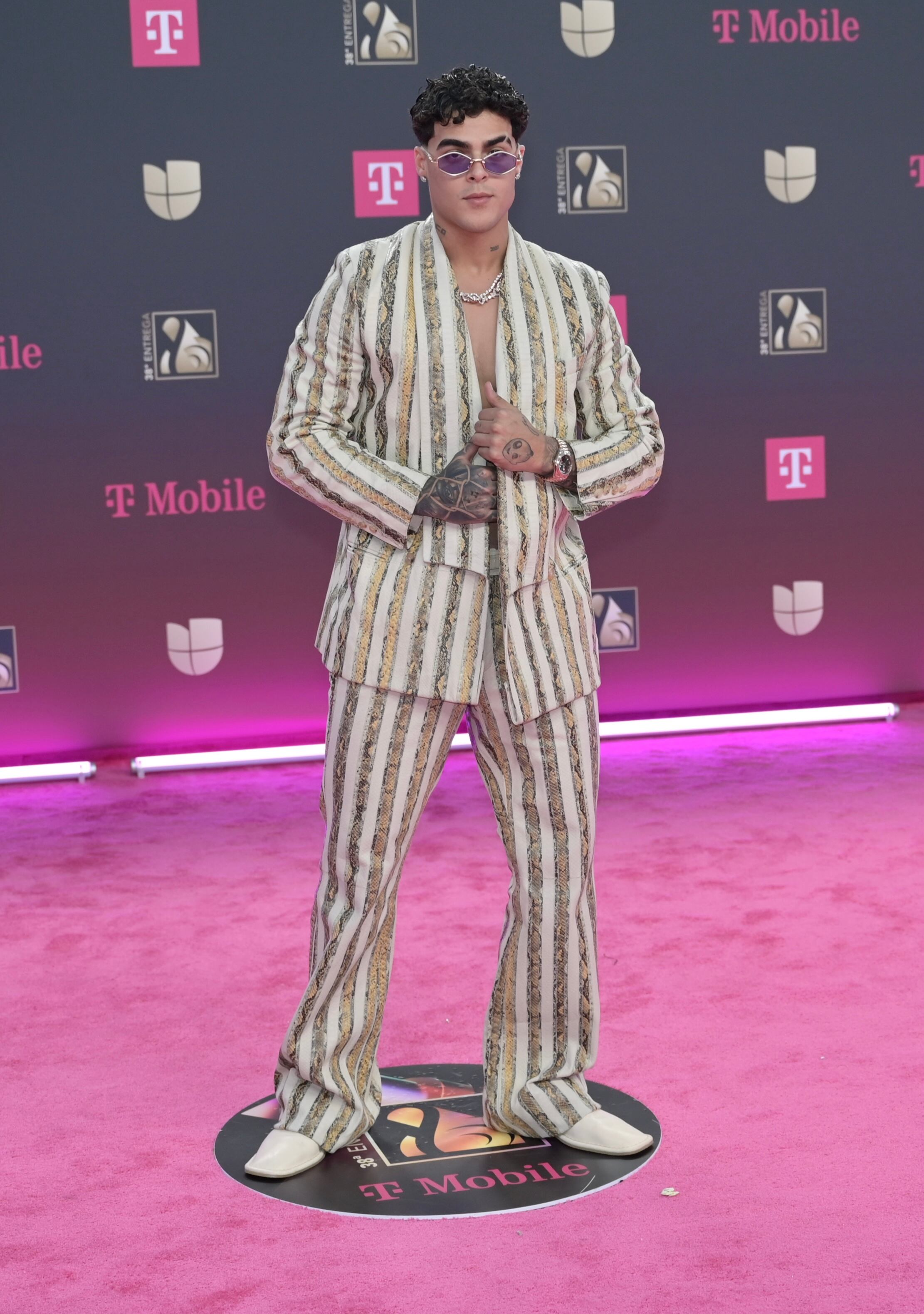 El artista urbano arriesgó con un traje a rayas, sin camisa, que no pasó desapercibido. Y no, tampoco se quitó las gafas de cristal rosado.