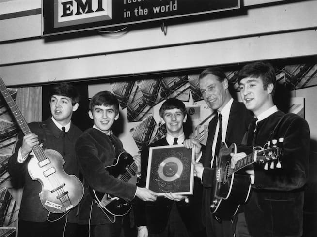 The Beatles sosteniendo su disco de platino