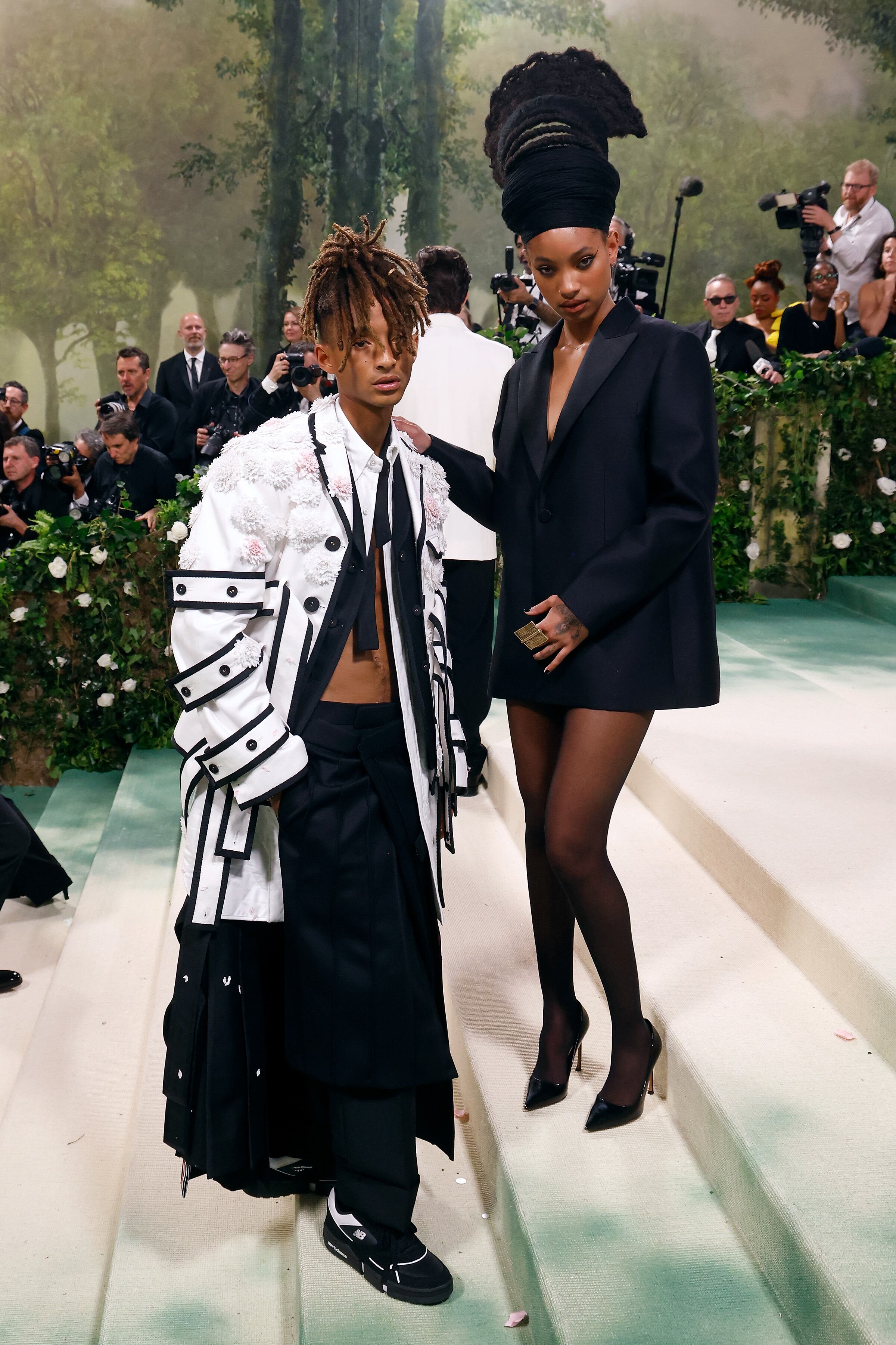 Desde 2016 no les veíamos juntos en este evento. Los hermanos Smith osaron a juego con sus estilismos. El de ella, un vestido blazer negro con medias del mismo color y stilettos y joyas doradas. Él apostó por una superposición de capas hecha de pantalón de vestir negro con una falda, una camisa de vestir abierta y un abrigo blanco cubierto de flores.