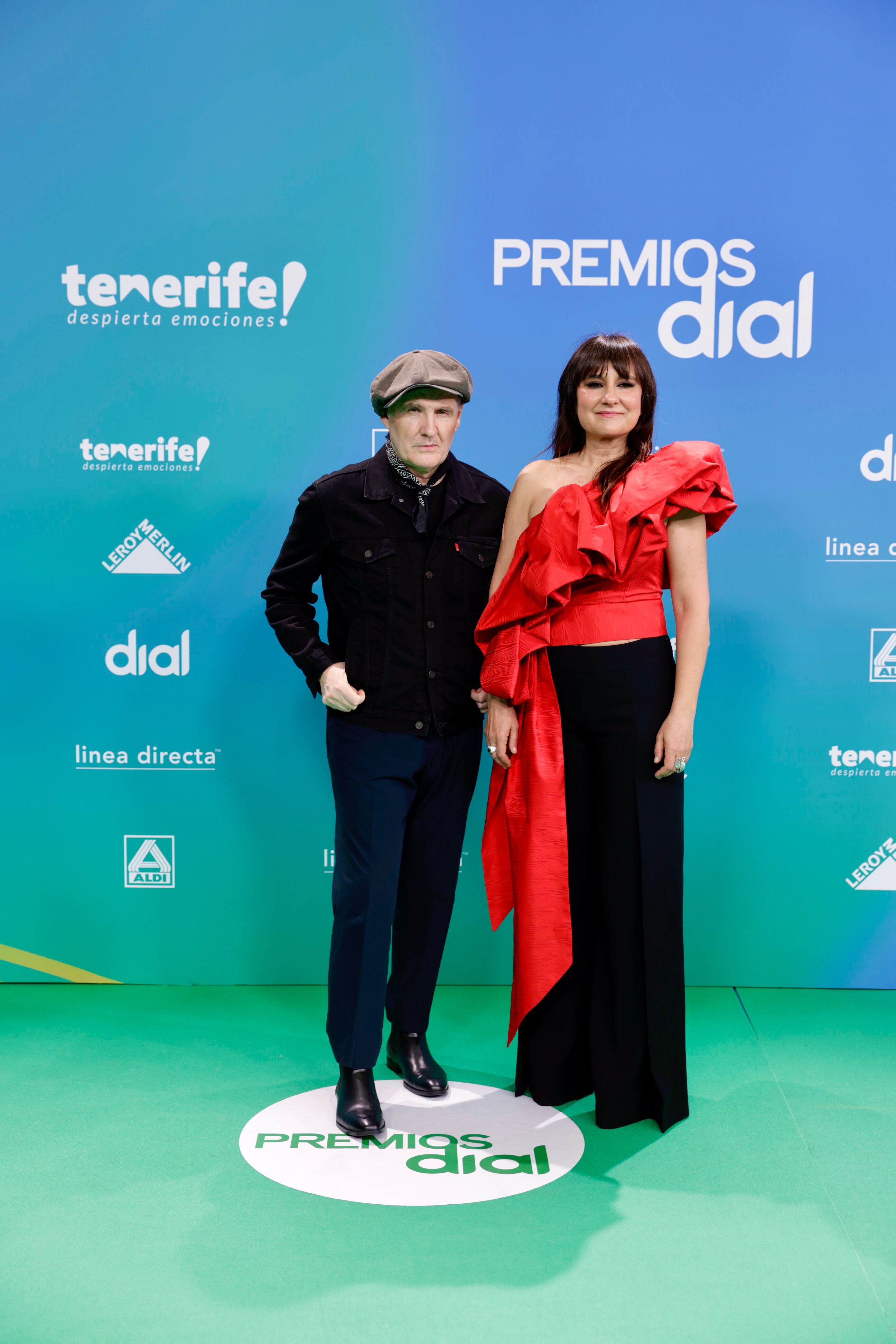 Juan Aguirre no ha dejado opción al color en su estilismo completamente negro, incluso para la gorra y el pañuelo al cuello. El mismo color del pantalón de Eva Amaral que, sin embargo, ha combinado con un cuerpo escultórico en rojo con una sola manga.
