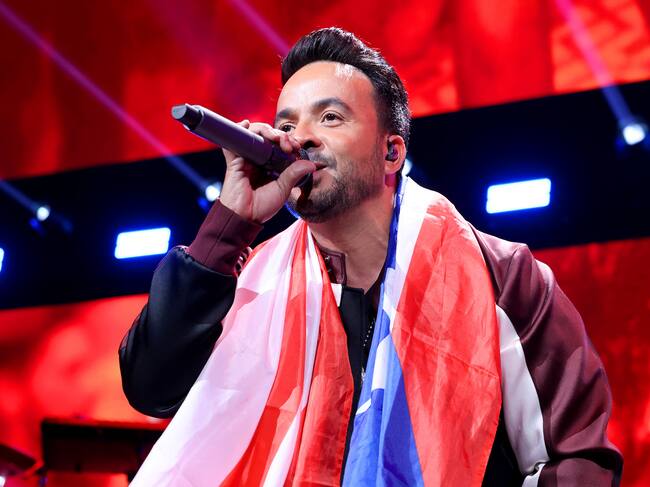Luis Fonsi cantando con la bandera de Puerto Rico al cuello